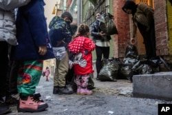 Children and their families wait their turn to be given coats and shoes by volunteers in the Tarlabaği neighborhood of Istanbul, Turkey on December 14, 2024.