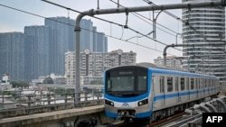 A train of Line 1 of the HCMC Metro is seen passing residential buildings in Ho Chi Minh City on December 22, 2024.