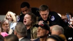 A protester is removed during the Senate Armed Services Committee confirmation hearing of Pete Hegseth, President-elect Donald Trump's pick as Secretary of Defense, at the Capitol in Washington on January 14, 2025.