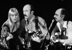 FILE - Folk trio Peter, Paul and Mary, from left, Mary Travers, Paul Stookey and Peter Yarrow, perform at a Los Angeles benefit in aid of Cambodian refugees, January 30, 1980.